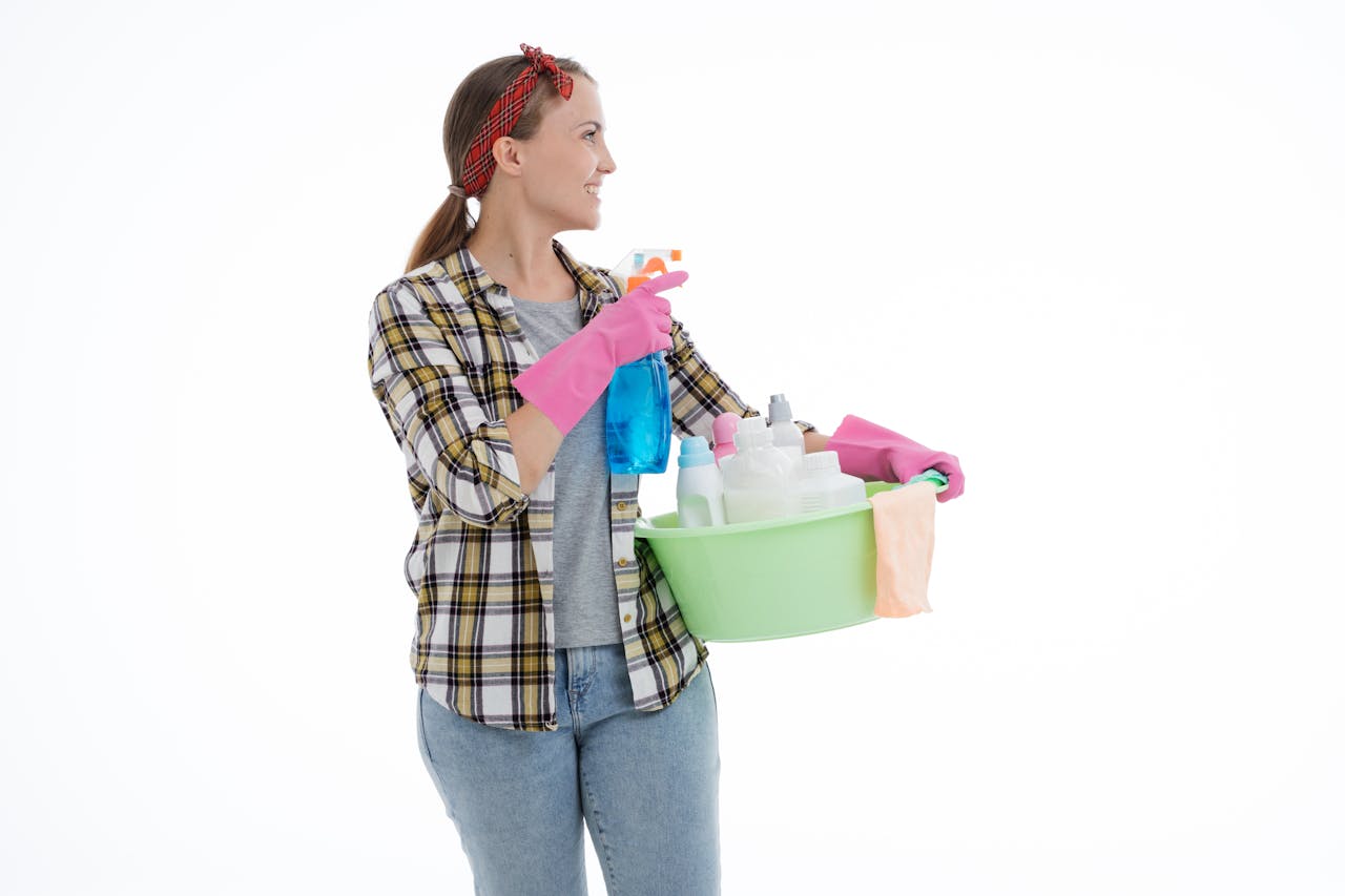 hero-img Woman holding cleaning supplies in a studio shot with a white background. Perfect for housekeeping themes.
